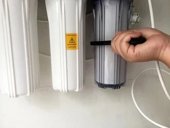 Technician repairing an RO filtration system